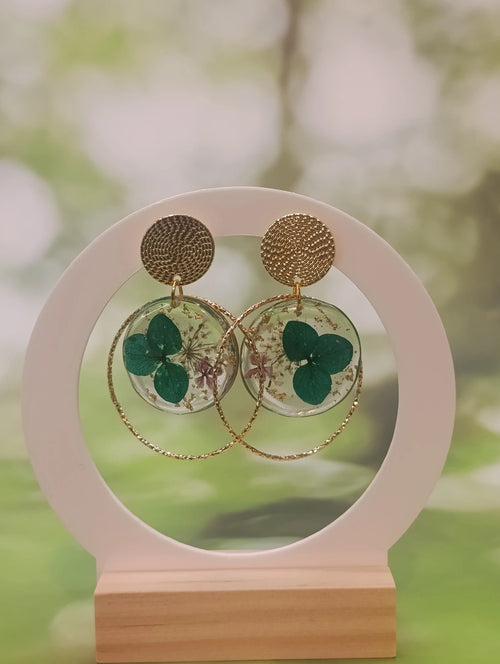 Boucles d'oreilles rondes en résine transparente avec hortensia vert, feuilles d'or et fleurs mauves, puce dorée tressée – A Fleur d'Or